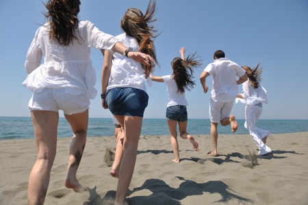 happy people group have fun  run and jump  on beach beautiful sand  beachの写真素材