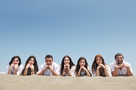 Group of happy young people in circle at beach have funの写真素材