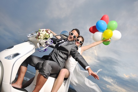 bride and groom on the beach ride a white scooter and have funの写真素材
