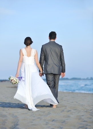 happy just married young couple celebrating and have fun at beautiful beach sunsetの写真素材