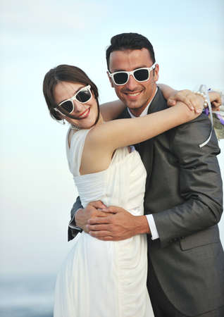 happy just married young couple celebrating and have fun at beautiful beach sunsetの写真素材