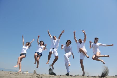 happy people group have fun  run and jump  on beach beautiful sand  beachの写真素材