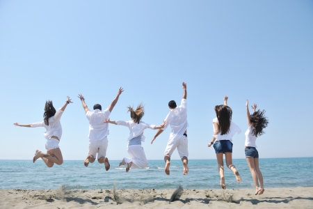 happy people group have fun  run and jump  on beach beautiful sand  beachの写真素材