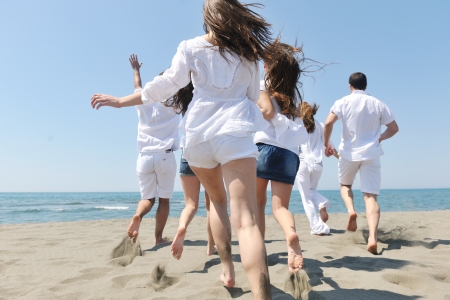 happy people group have fun  run and jump  on beach beautiful sand  beachの写真素材
