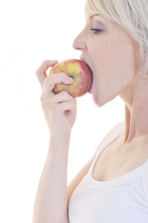 woman eat green apple isolated  on white backround in studio representing healthy lifestile and eco food conceptの写真素材