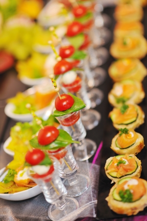 buffed food closeup of  fruits, vegetables, meat and fish arranged on banquet tableの写真素材