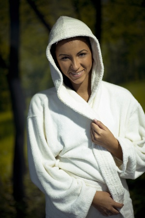 Pretty Young woman take a steam bath treatment at finish wooden sauna while wearing white towelの写真素材