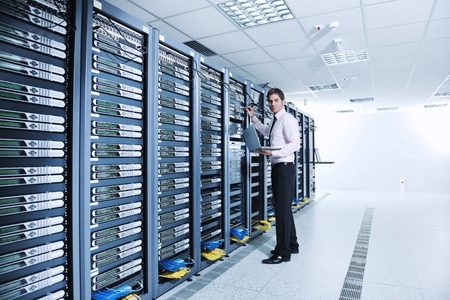 young engeneer business man with thin modern aluminium laptop in network server roomの写真素材