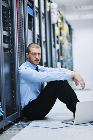 young engineer business man with thin modern aluminium laptop in network server roomの写真素材