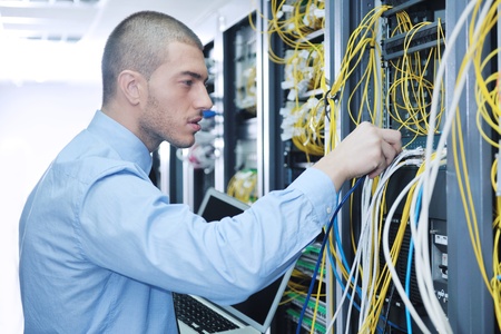 young engeneer business man with thin modern aluminium laptop in network server roomの写真素材
