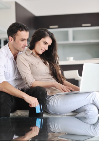 joyful couple relax and work on laptop computer at modern living room indoor homeの写真素材