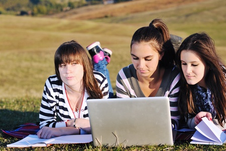 group of teen girl woman outdoor have fun and study homework on laptop computerの写真素材