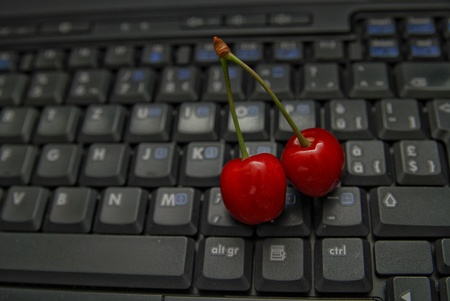 fresh cherry closeup on laptop keyboardの写真素材