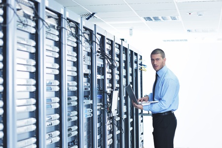 young engeneer business man with thin modern aluminium laptop in network server roomの写真素材