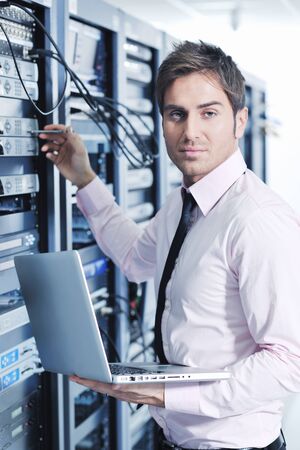 young engeneer business man with thin modern aluminium laptop in network server roomの写真素材