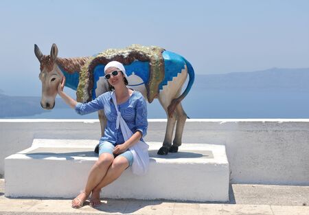Beautiful young Greek woman in fashion clothes have fun at n the streets of Oia, Santorini, Greeceの写真素材