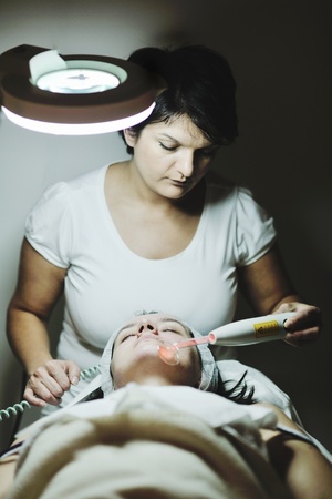 Young beautiful woman receiving cosmetic facial mask in spa beauty salon and relaxの写真素材
