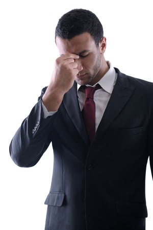 Portrait of a young business man looking depressed from work isolated over white background in studioの写真素材