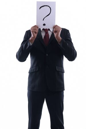 Business man holding a piece of paper over his face with a question mark on it isolated on white background in studioの写真素材