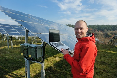 business man  engineer using laptop at solar panels plant eco energy field  in backgroundの写真素材