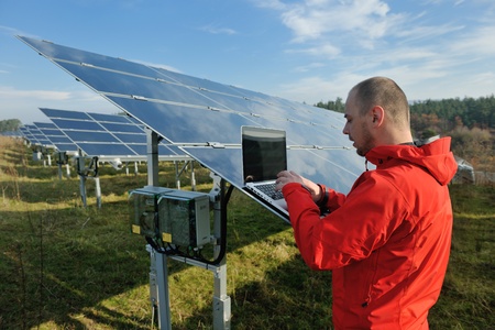 business man  engineer using laptop at solar panels plant eco energy field  in backgroundの写真素材