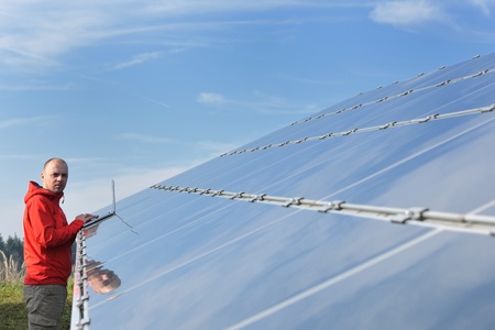 business man  engineer using laptop at solar panels plant eco energy field  in background