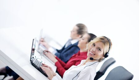 Pretty young business woman group with headphones smiling at you against white background