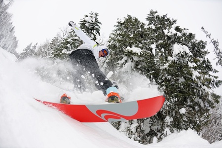 Snowboarder doing a jump and free ride on  powder snow at winter seasonの写真素材