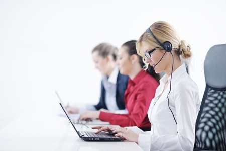 Pretty young business woman group with headphones smiling at you against white backgroundの写真素材