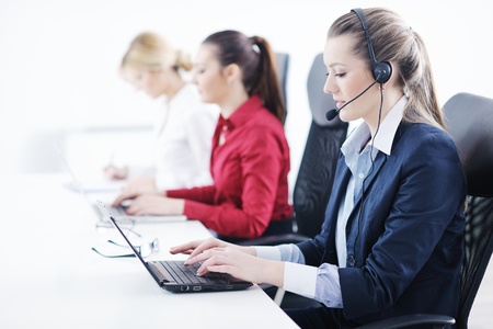 Pretty young business woman group with headphones smiling at you against white backgroundの写真素材