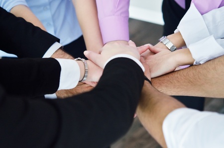business people group joining hands and representing concept of friendship and teamwork,  low angle viewの写真素材