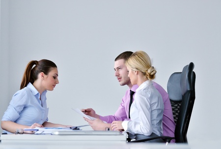 Group of young business people sitting in board room during meeting and discussing with paperworkの写真素材
