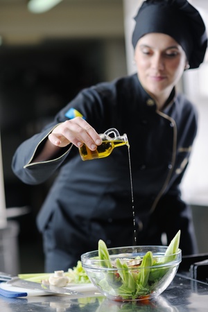 beautiful young chef woman prepare and decorating tasty food in kitchenの写真素材