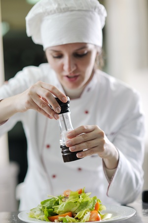 beautiful young chef woman prepare and decorating tasty food in kitchenの写真素材