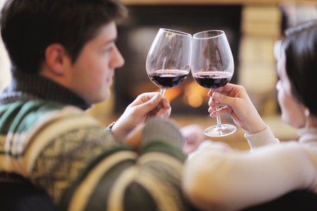 happy Young romantic couple and relaxing sofa in front of fireplace at winter season in homeの写真素材