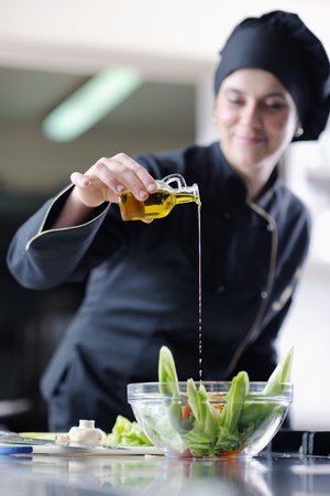 beautiful young chef woman prepare and decorating tasty food in kitchenの写真素材