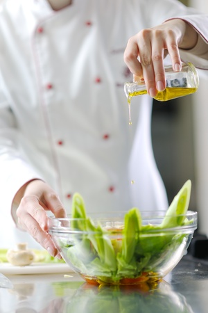 beautiful young chef woman prepare and decorating tasty food in kitchenの写真素材