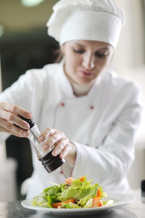 beautiful young chef woman prepare and decorating tasty food in kitchenの写真素材