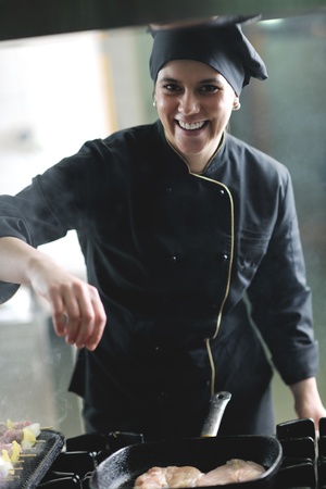 beautiful young chef woman prepare and decorating tasty food in kitchenの写真素材