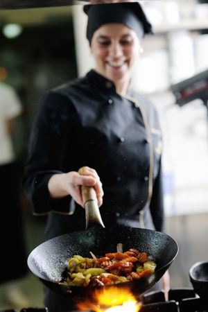 beautiful young chef woman prepare and decorating tasty food in kitchenの写真素材