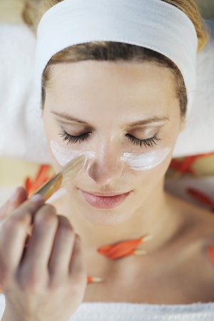 Beautiful young woman in spaand wellness. Face back and  stone massageの写真素材