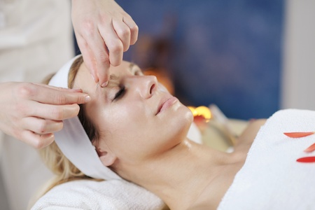 Beautiful young woman in spaand wellness. Face back and  stone massageの写真素材