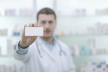 portrait of handsome young  pharmacist chemist man standing in pharmacy drugstore
