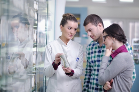young pharmacist suggesting medical drug to buyer in pharmacy drugstoreの写真素材