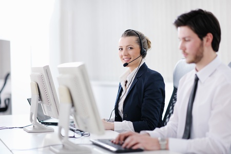 business people group with  headphones giving support in  help desk office to customers, manager giving training and education instructionsの写真素材