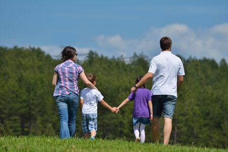 happy young family with their kids have fun and relax outdoors in nature with blue sky in backgroundの写真素材