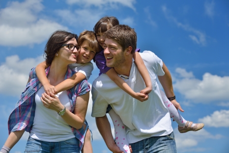 happy young family with their kids have fun and relax outdoors in nature with blue sky in backgroundの写真素材