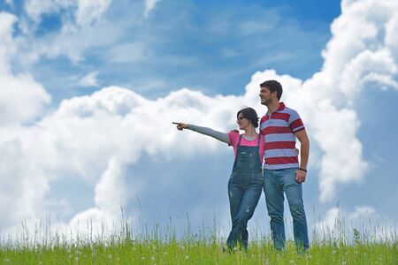 Portrait of romantic young couple in love  smiling together outdoor in nature with blue sky in backgroundの写真素材