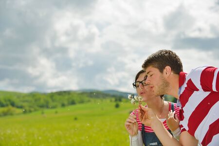 Portrait of romantic young couple in love  smiling together outdoor in nature with blue sky in backgroundの写真素材
