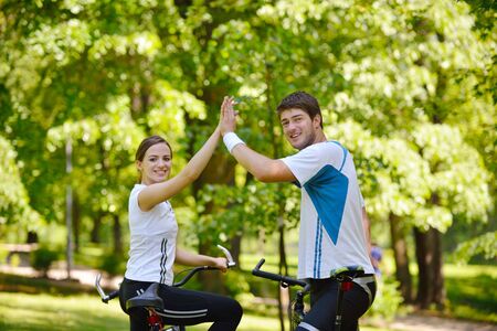 Happy couple riding bicycle outdoors, health lifestyle fun love romance conceptの写真素材